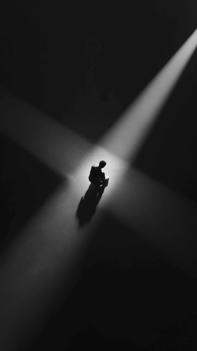 3D perspective from above looking down on a lone silhouette on its knees. Its hands are cupped, and a single, faint point of light in shape of a cross emanates from above them, the only illumination in the total darkness, symbolizing a fragile hope. Cinematic still, black and white photo, claustrophobic atmosphere, deep shadows.